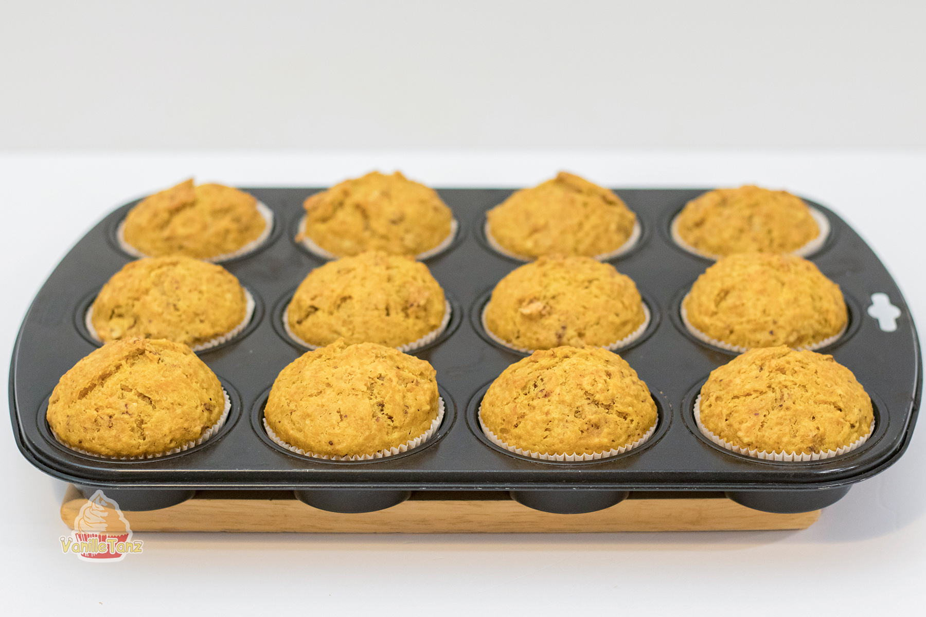 Muffin Backform für zwölf Muffins mit fertig gebackenen Karotten Muffins
